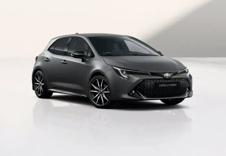 Szary hatchback Toyota Corolla 1.8 Hybrid z czarnymi felgami stoi na białym tle.