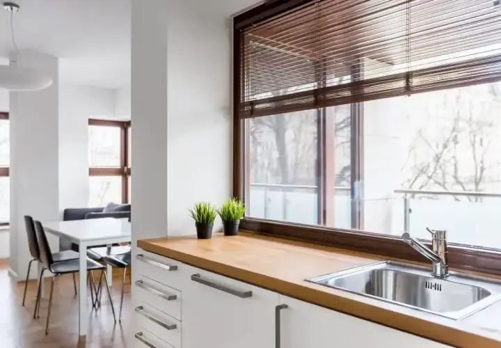 Nowoczesne oświetlenie nad oknem w kuchni, z widokiem na balkon i jadalnię.