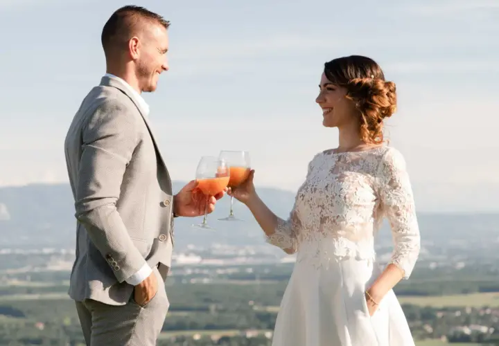 Jeune mariés trinquant avec des verres de boisson fruitée, une belle quantité pour célébrer leur amour.