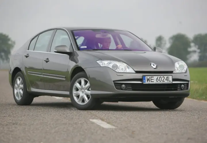 Szary sedan Renault Laguna 3 na drodze. Rozmiar opon jest standardowy dla tego modelu, zapewniając komfortową jazdę.