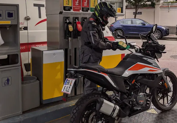 Motociclista repostando su moto 125. La pregunta clave es: ¿qué gasolina usan las motos 125? Generalmente, usan gasolina sin plomo de 95 octanos.