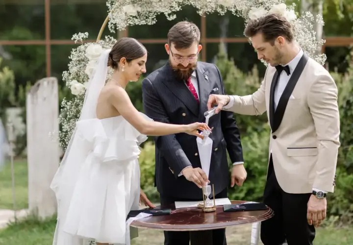 Para młoda i celebrans podczas ceremonii wsypywania piasku.