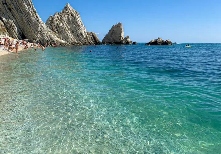 Spiaggia delle Due Sorelle: come arrivare a questo paradiso. Acque cristalline, scogliere imponenti e bagnanti che si godono il sole.