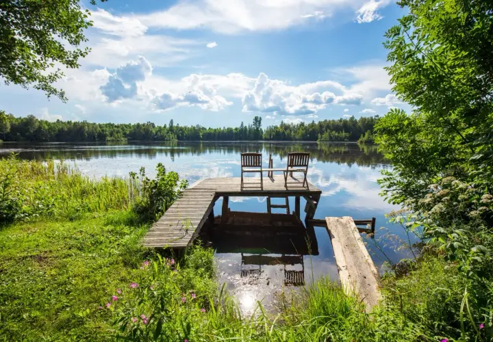 Drewniane pomosty i dwa krzesła nad spokojnymi jeziorami w Borach Tucholskich.