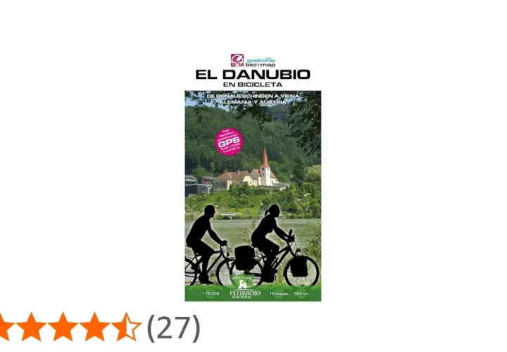 Ruta en bici por el Danubio, de Alemania a Austria. Paisaje fluvial con ciclistas y un pueblo con iglesia.