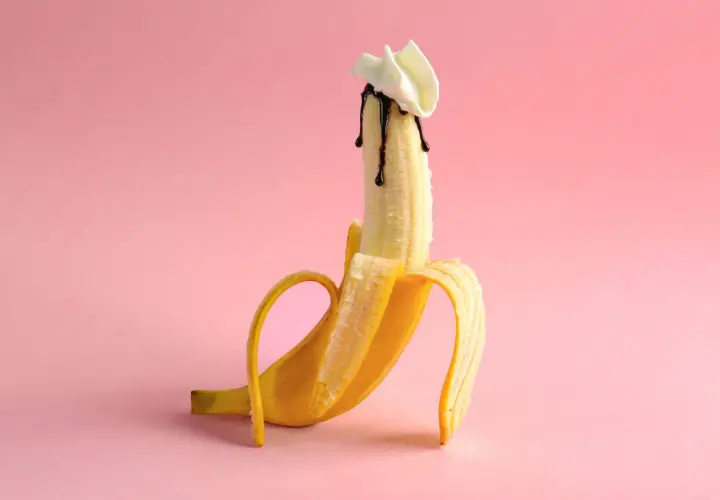 Banan z polewą czekoladową i bitą śmietaną, sugerujący polknięcie spermy.