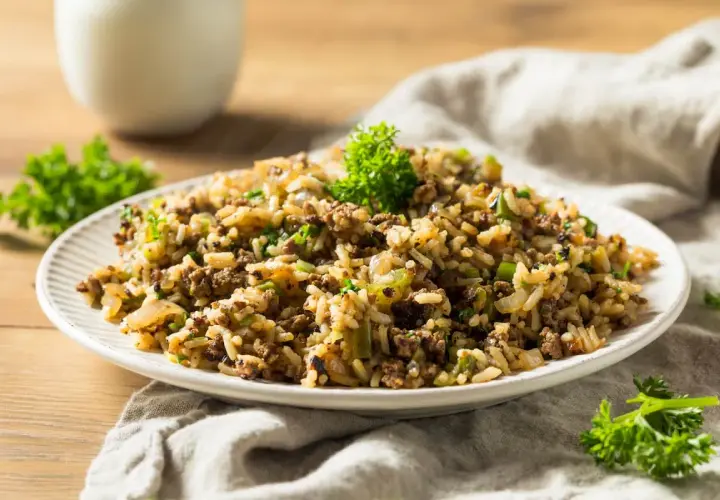 Plato de arroz integral con carne molida y verduras, decorado con perejil fresco.