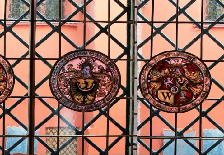 Witraże z herbami zdobią okna muzeum sztuki mieszczańskiej, ukazując bogactwo dawnych rodów.