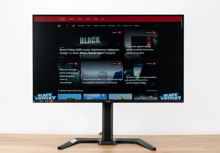 Monitor z widocznym na ekranie portalem Pcelite.pl, prezentującym artykuły o tematyce technologicznej, w tym promocje z okazji Black Friday. Test matrycy monitora jest kluczowy dla oceny jakości obrazu.