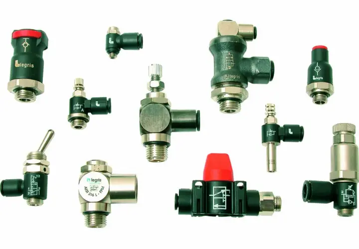 Varios componentes neumáticos Legris, incluyendo válvulas y conectores para tubo, dispuestos sobre fondo blanco.