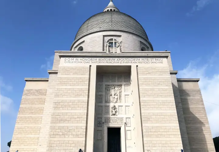 La maestosa chiesa San Pietro e Paolo domina il cielo azzurro, con la sua imponente cupola e iscrizioni latine che celebrano gli apostoli.