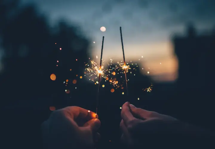 Mani che accendono scintille al tramonto, un modo magico per festeggiare, come si dice capodanno in inglese?