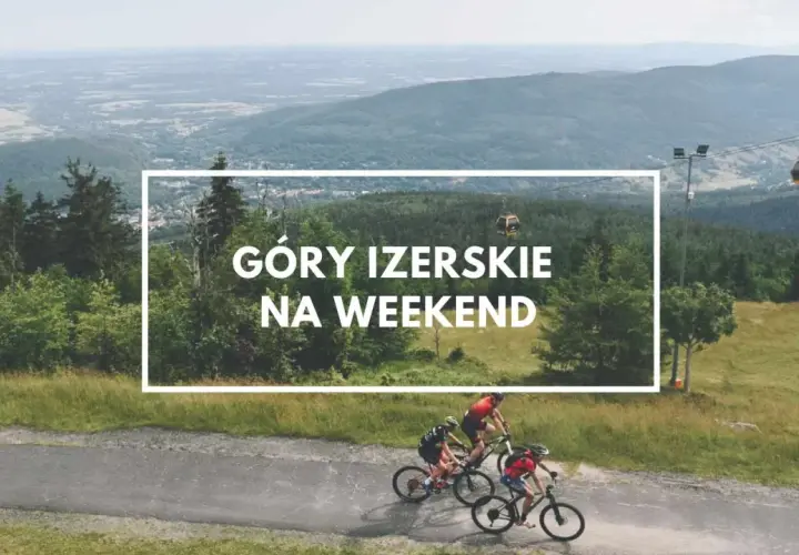 Trzech rowerzystów przemierza malownicze Góry Izerskie. W tle widać kolejkę gondolową i rozległą panoramę.