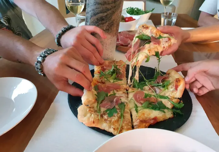 Pieczenie pizzy na kamieniu zakończone sukcesem! Rozciągający się ser i rukola kuszą.
