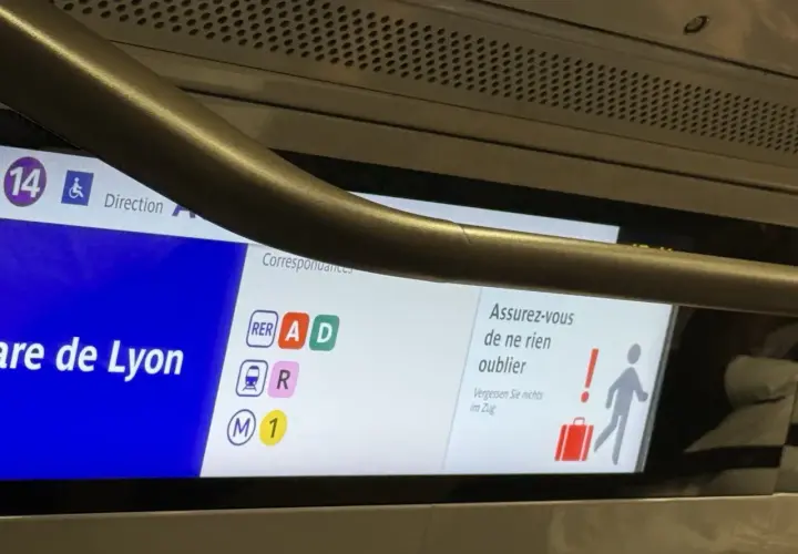 Wyświetlacz w pociągu RER z informacją o stacji Gare de Lyon i symbolami linii.