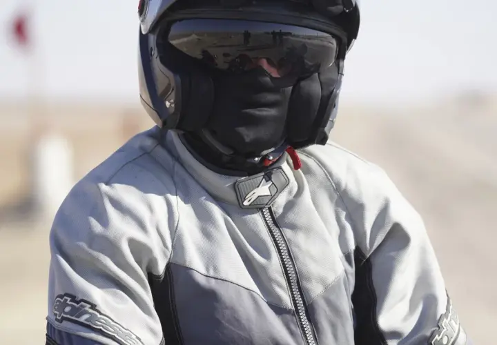 Motociclista con casco y pasamontañas, listo para viajar sin pasar frío en moto.