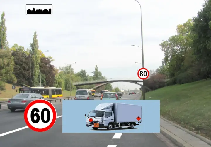 Na drodze widać znak w21 informujący o końcu obszaru zabudowanego. Obok znak ograniczenia prędkości do 60 km/h. W tle jadą samochody i autobusy.