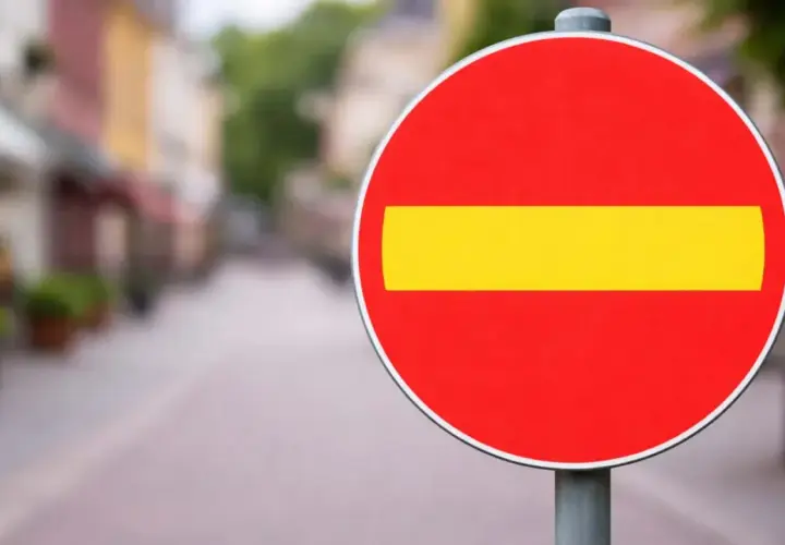 En röd cirkel med ett gult streck i mitten. En stoppskylt som signalerar stopp.