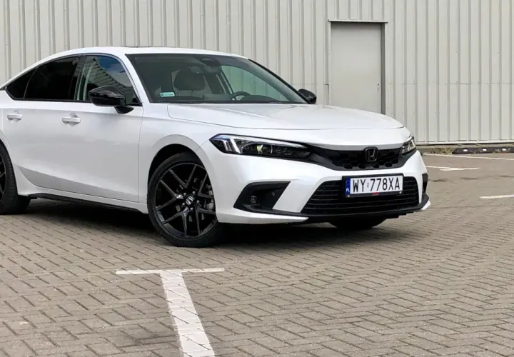 Biały Honda Civic 2025 z czarnymi felgami stoi na parkingu.