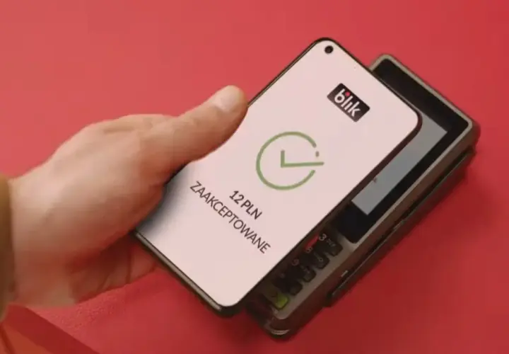 Zbliżeniowa płatność telefonem przez blik. Na ekranie telefonu widnieje potwierdzenie transakcji 12 PLN.