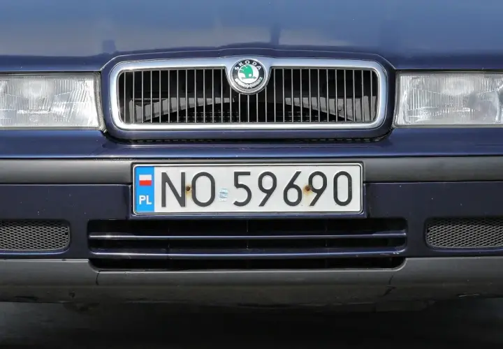 Niebieska Skoda z tablicą rejestracyjną NO 59690. Cały przód auta, grill i światła.