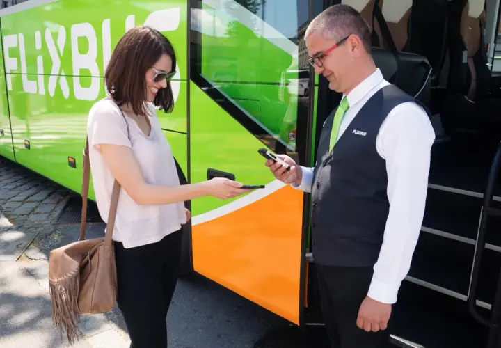 Kobieta pokazuje bilet na telefonie kierowcy Flixbus. Warto szukać flixbus promocje na podróże!