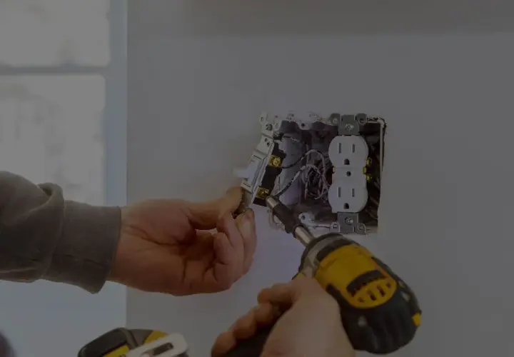Elektryk montuje gniazdko i włącznik. Zastanawiasz się, ile kosztuje godzina pracy elektryka?