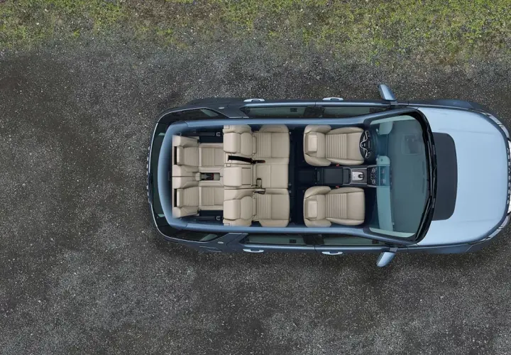 Widok z góry na wnętrze Land Rover Discovery z jasnymi, skórzanymi siedzeniami, gotowe na rodzinną podróż.