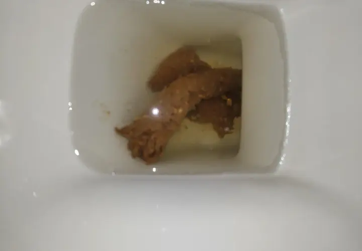 W kale widoczne są brązowe fragmenty i drobne białe grudki.