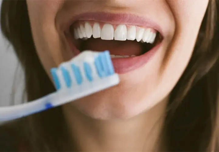 Sorriso smagliante con denti bianchi e spazzolino. Dedicare 10 minuti a lavarsi i denti garantisce un sorriso sano e luminoso.