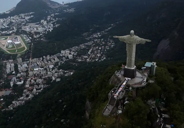 Widok na Rio de Janeiro z pomnikiem Chrystusa Odkupiciela. Widać gęstą zabudowę miasta i zalesione wzgórza, świadczące o dużej brazylijskiej ludności.