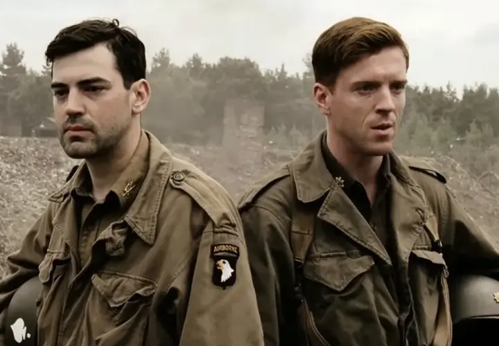 Dwóch żołnierzy w mundurach, symbolizujących bandę braci, stoi na tle zniszczeń. Jeden z nich ma naszywkę "AIRBORNE".