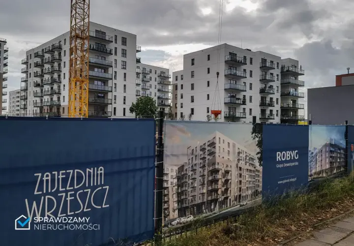 Budowa osiedla mieszkaniowego w Gdańsku, widoczne dźwigi i banery deweloperskie.