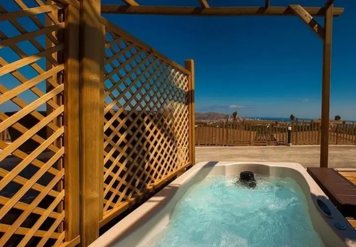 Jacuzzi burbujeante en un balcón con vistas al mar, parte de la experiencia mágica en Natura Resort.