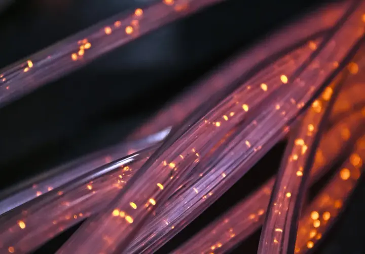 Światłowody FTTH, czyli "Fiber to the Home", to nowoczesna technologia dostarczania internetu. Widać tu ich skupisko, rozświetlone pomarańczowymi iskierkami.