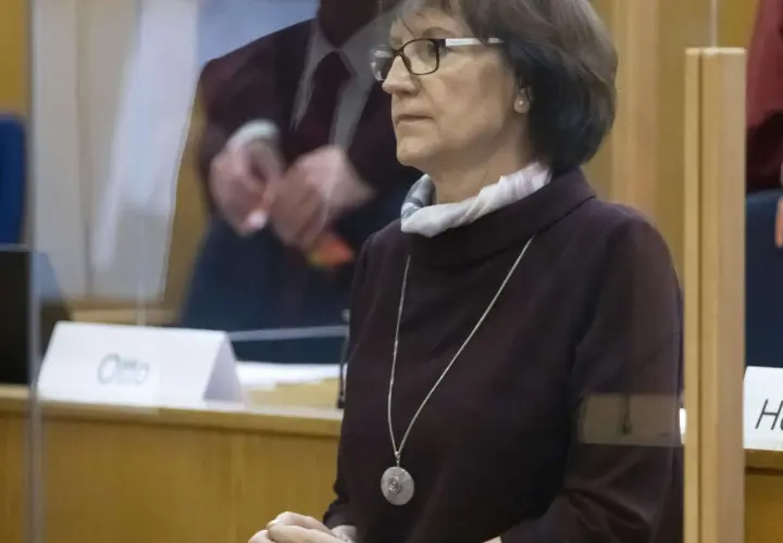 Frau mit Brille und Kette im Gerichtssaal, möglicherweise die stephan ernst ehefrau, blickt nachdenklich.