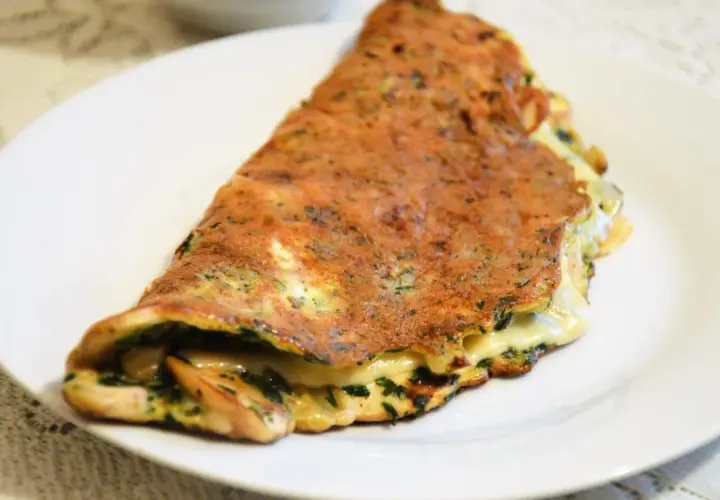 Złocisty omlet z serem i ziołami, idealny pomysł na szybką kolację.