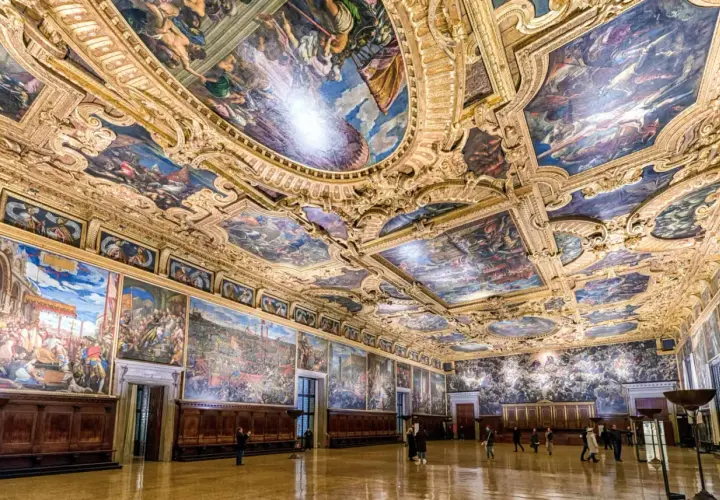 Intérieur grandiose du palais des Doges, plafonds peints et dorés racontant l'histoire de Venise. Des fresques monumentales ornent les murs et le plafond, témoins de la splendeur passée.