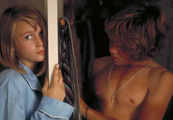 Ann-Sofie Kylin i blå pyjamas tittar mot en pojke med halsband.