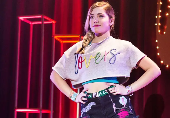 Młoda dziewczyna z warkoczem, w crop topie z napisem "lovers", pewnie pozuje na scenie. To część obsady "Go! Żyj po swojemu".