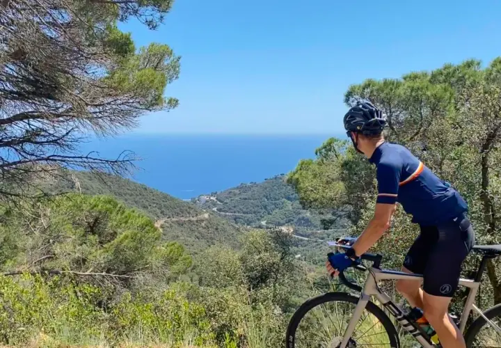 Cyclist enjoys a scenic ride, taking in breathtaking coastal views. This could be one of the best cycling routes in Europe.