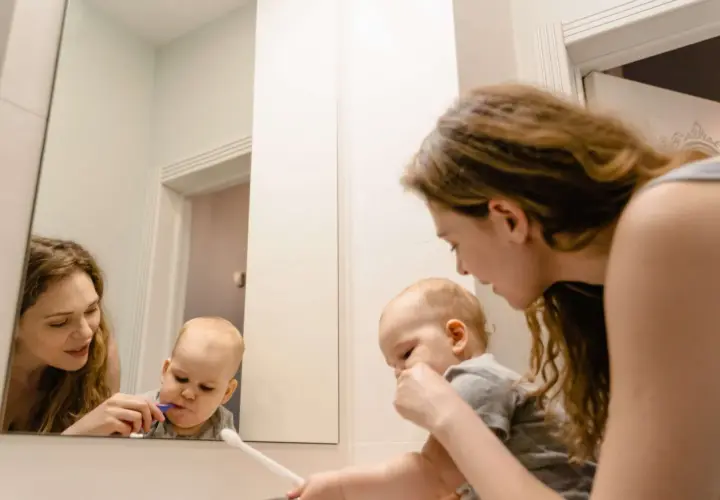Mama pomaga dziecku myć zęby. Maluch ma lekki odruch wymiotny przy myciu zębów, ale mama go uspokaja.