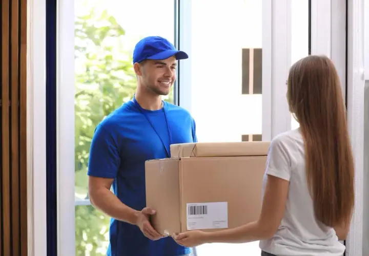 Lieferbote übergibt Frau ein Paket. Sie hofft, dass es nicht die **nicht bestellte Ware** ist, die sie schon einmal erhalten hat.