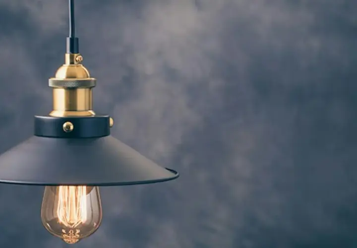 Stylowa lampa wisząca z czarnym kloszem i złotymi elementami. To modne oświetlenie idealnie wpasuje się w industrialne wnętrza.