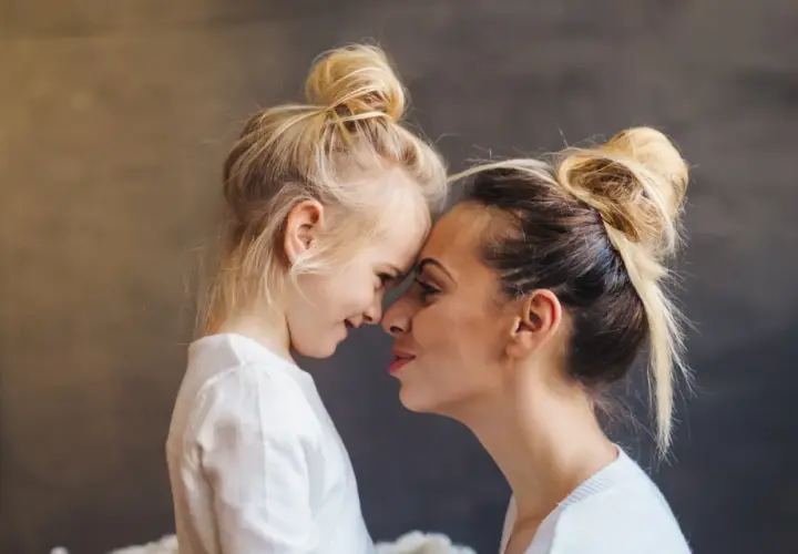 Blondynka z córką, dziecko z poprzedniego związku, czule dotykają się noskami. Nowy partner wkracza w ich życie.