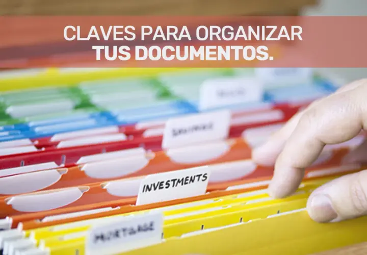 Una mano revisa carpetas de colores para la gestión documental y organización de archivos.