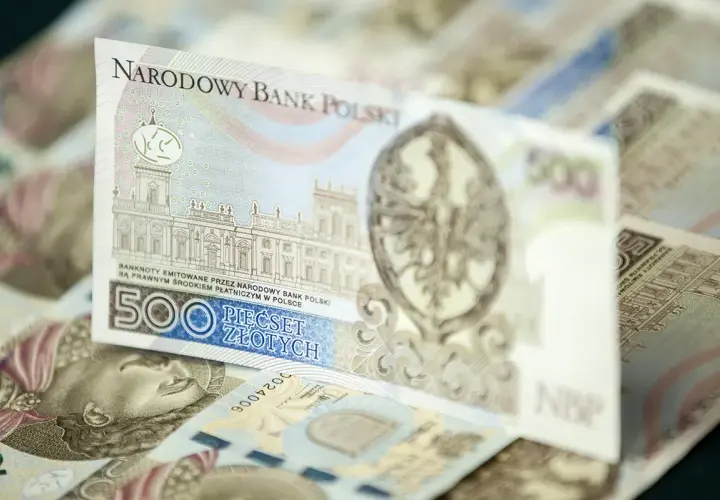 Stos banknotów 500 zł. Widoczny fragment z budynkiem i orłem.