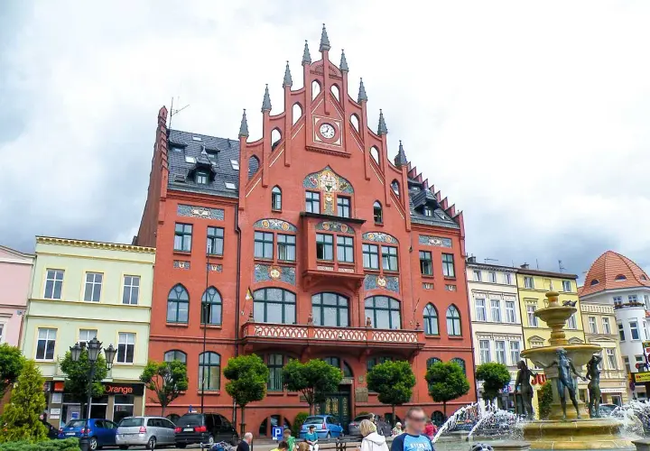 Rynek w Chojnicach z ratuszem i fontanną. Atrakcje miasta przyciągają turystów.