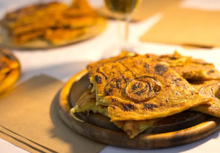 Farinata dorata, un classico per sapere cosa mangiare a Pisa. Croccante fuori, morbida dentro, con cipolle caramellate.