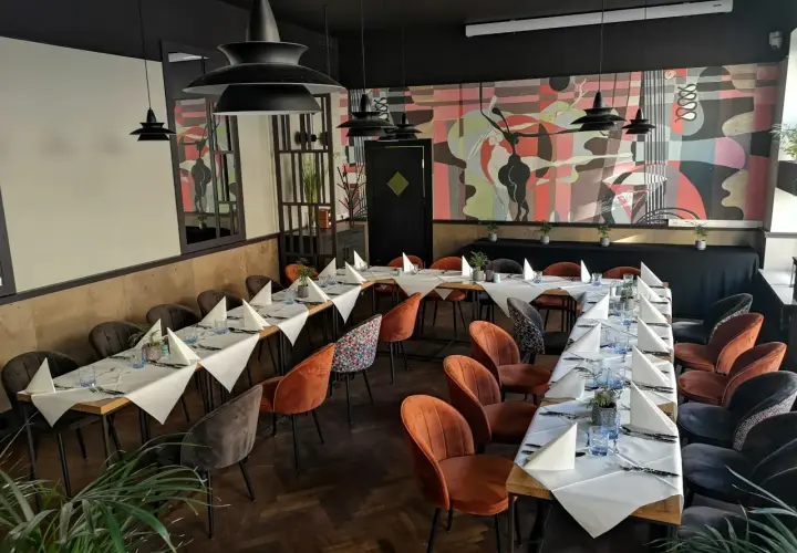 Elegancka sala bankietowa z nakrytymi stołami, idealna na wyjątkowe okazje. To miejsce to prawdopodobnie najlepsza restauracja w Olsztynie.